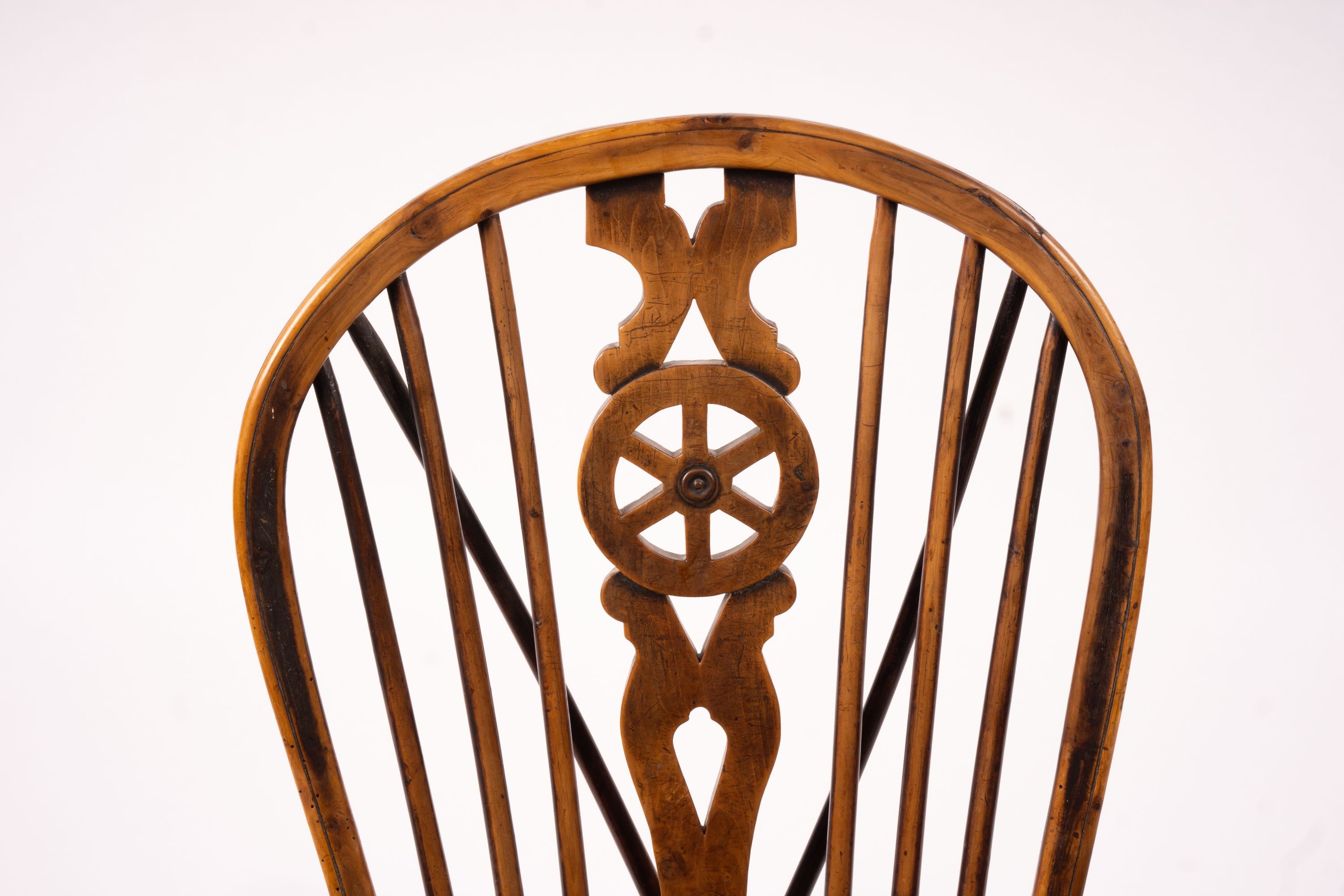 A mid 19th century ash and elm Derbyshire area Windsor elbow chair, together with a 19th century yew and elm Windsor wheel back chair with crinoline stretcher